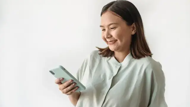 Woman smiling while holding a smartphone
