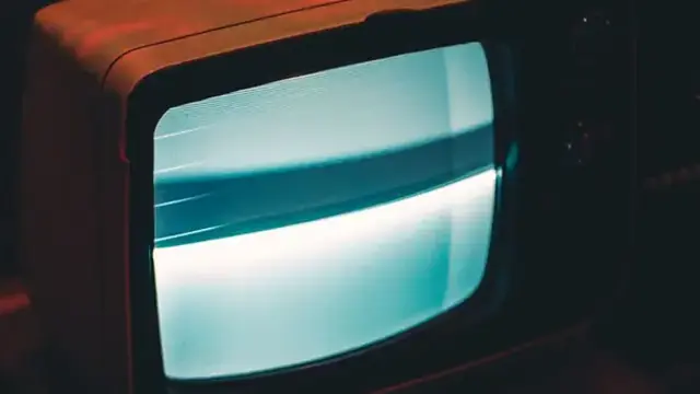 Television screen glowing in a dark room