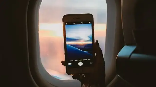 View from an airplane window with a phone in hand