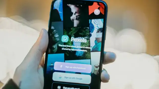 Hand holding a smartphone with apps visible