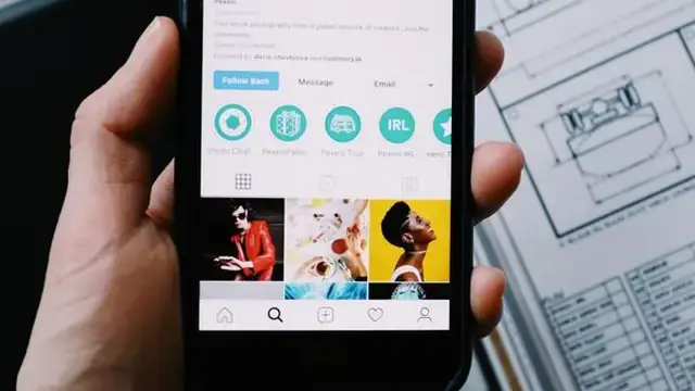 Hand holding an Android phone showing an app install screen