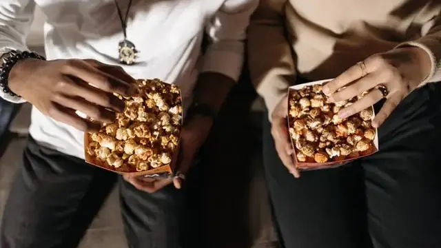 Popcorn and a drink on a table during a home movie night