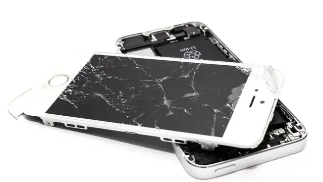 Broken smartphone with a cracked screen on a white background