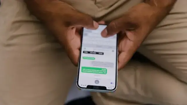 Hand holding a smartphone showing the settings screen