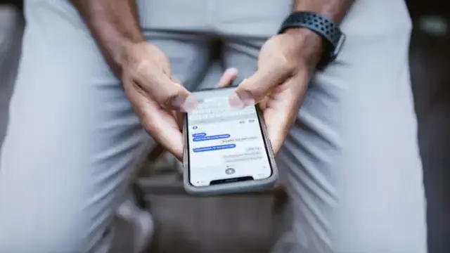 Person using a smartphone, close-up of hands typing
